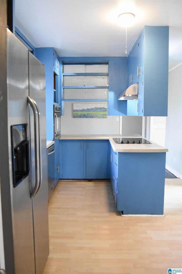 kitchen with blue cabinets, kitchen peninsula, appliances with stainless steel finishes, and light hardwood / wood-style flooring