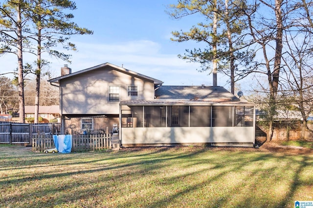 rear view of property featuring a yard and a sunroom