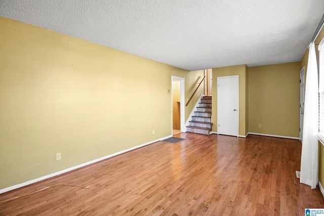 spare room featuring hardwood / wood-style floors and a textured ceiling