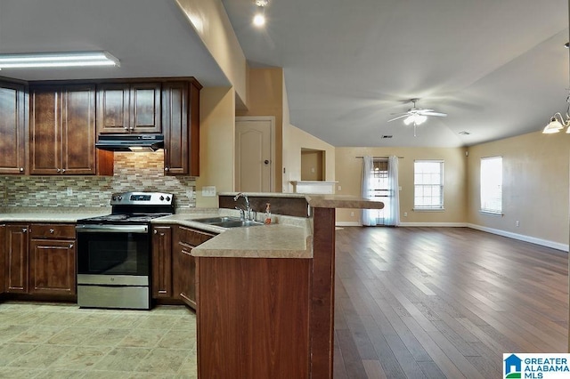 kitchen with sink, tasteful backsplash, pendant lighting, stainless steel electric stove, and ceiling fan with notable chandelier