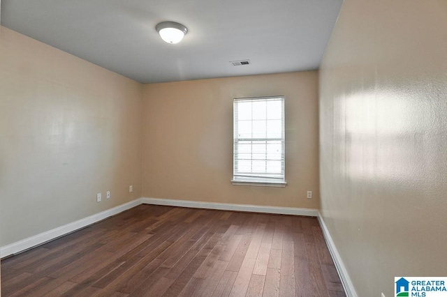 spare room with dark hardwood / wood-style flooring