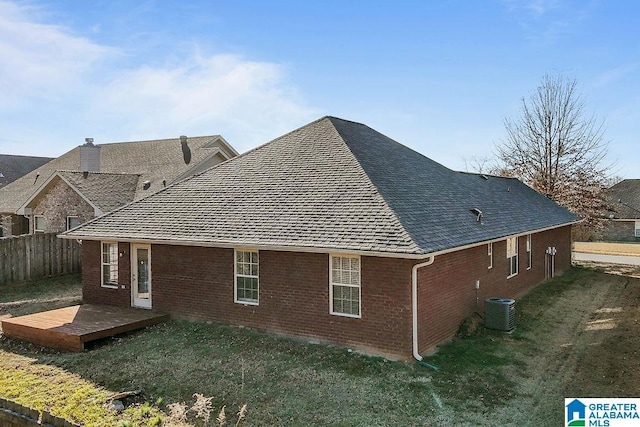 back of house with a deck, central AC unit, and a lawn