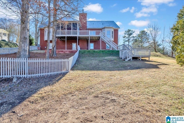 rear view of property with a deck and a yard