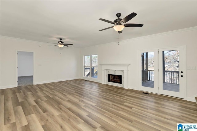 unfurnished living room featuring a premium fireplace, crown molding, light hardwood / wood-style flooring, and ceiling fan