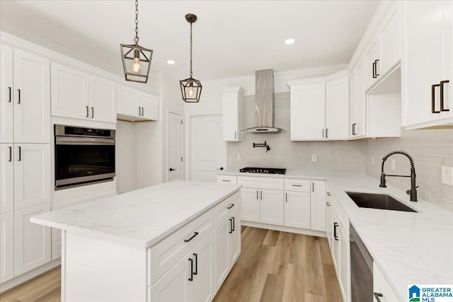 kitchen with stainless steel appliances, tasteful backsplash, wall chimney range hood, a kitchen island, and sink