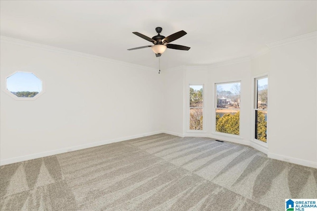 spare room with ceiling fan, light colored carpet, and ornamental molding