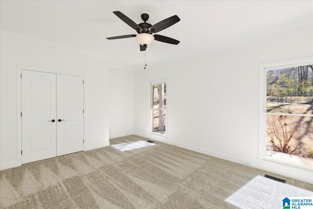 carpeted empty room featuring ceiling fan and ornamental molding