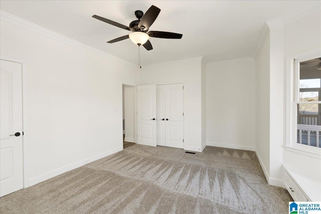 unfurnished bedroom with ceiling fan, light carpet, and crown molding