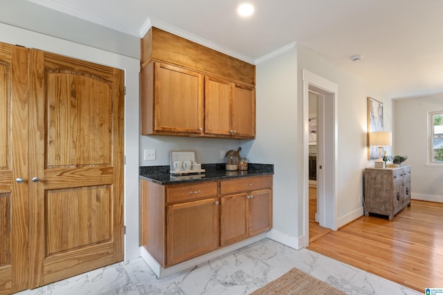 kitchen with ornamental molding and dark stone countertops