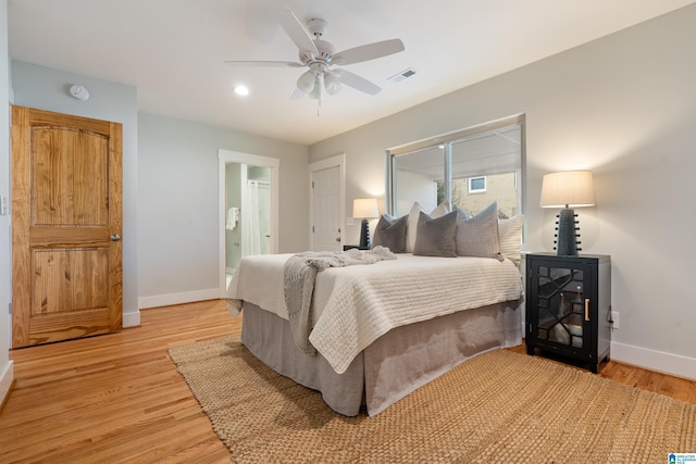 bedroom with ensuite bathroom, ceiling fan, and light hardwood / wood-style flooring