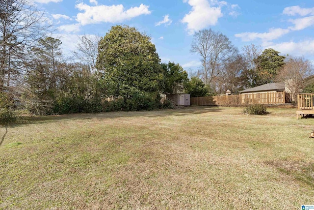 view of yard featuring a wooden deck and a storage shed