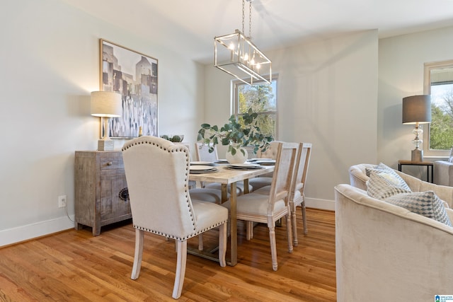 dining room with a chandelier, light wood-type flooring, and a wealth of natural light