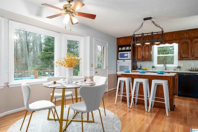 kitchen with ceiling fan, light hardwood / wood-style floors, white appliances, decorative backsplash, and a kitchen island