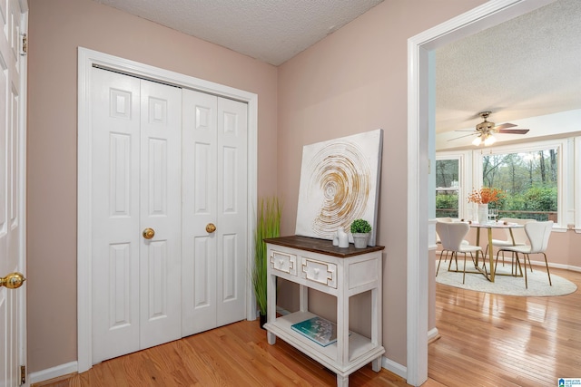 interior space with ceiling fan, a textured ceiling, and hardwood / wood-style flooring