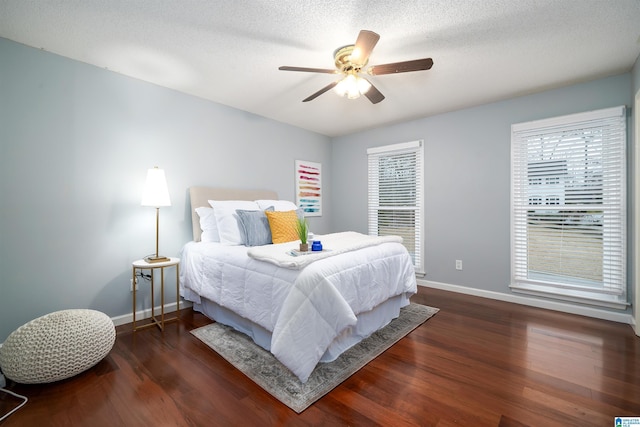 bedroom with a textured ceiling, ceiling fan, and dark hardwood / wood-style floors