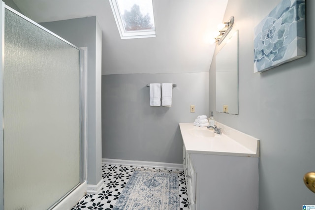 bathroom featuring vanity, a shower with shower door, and lofted ceiling with skylight