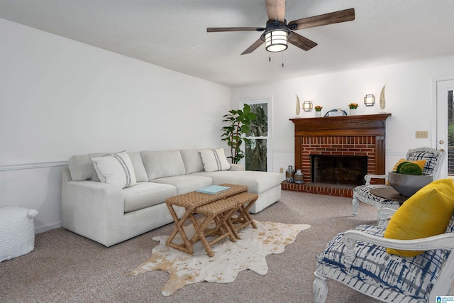 carpeted living room with ceiling fan and a brick fireplace