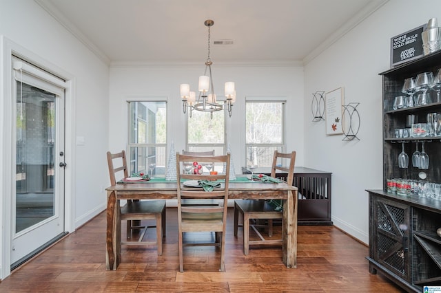 dining space with ornamental molding, dark hardwood / wood-style floors, and a notable chandelier