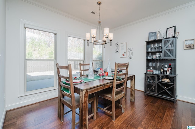 dining room featuring an inviting chandelier, dark hardwood / wood-style floors, and ornamental molding