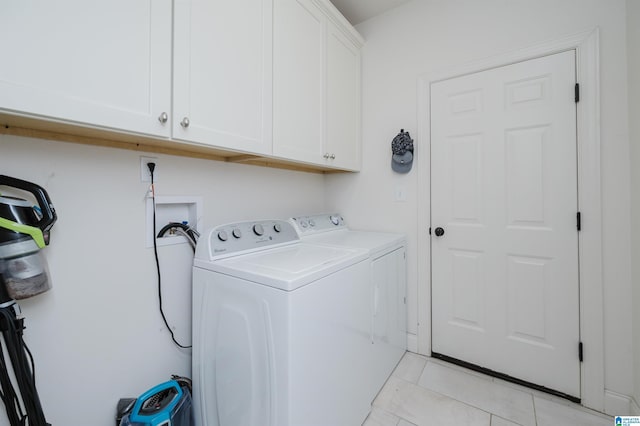 laundry area featuring washer and dryer, cabinets, and light tile patterned floors