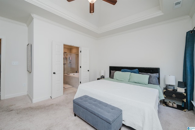 bedroom with light colored carpet, a raised ceiling, ceiling fan, crown molding, and connected bathroom