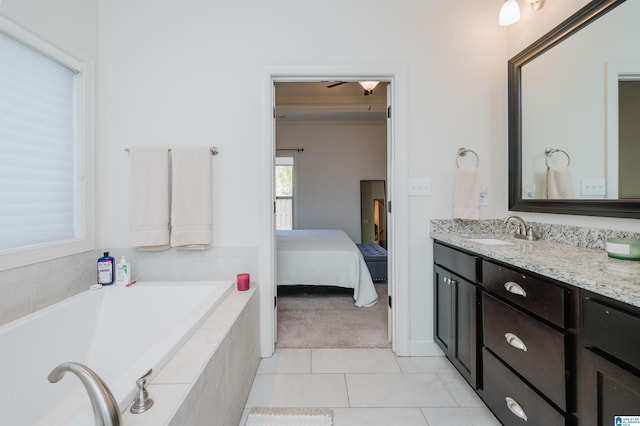 bathroom featuring vanity, a relaxing tiled tub, tile patterned floors, and ceiling fan