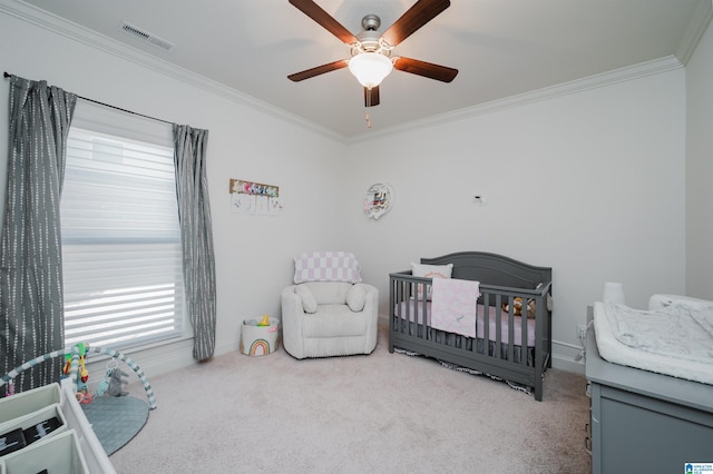 carpeted bedroom featuring ceiling fan, ornamental molding, and a nursery area