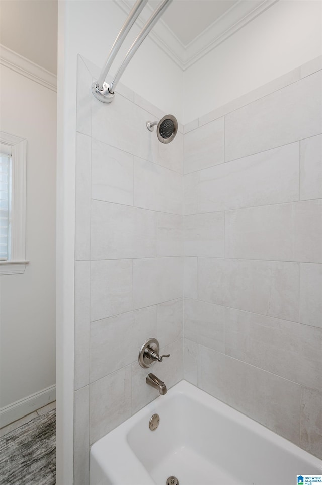 bathroom with tiled shower / bath combo and crown molding