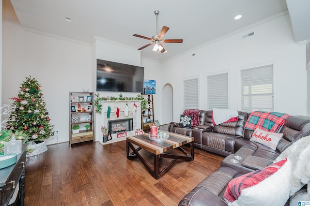 living room featuring a fireplace, dark hardwood / wood-style flooring, ceiling fan, and ornamental molding