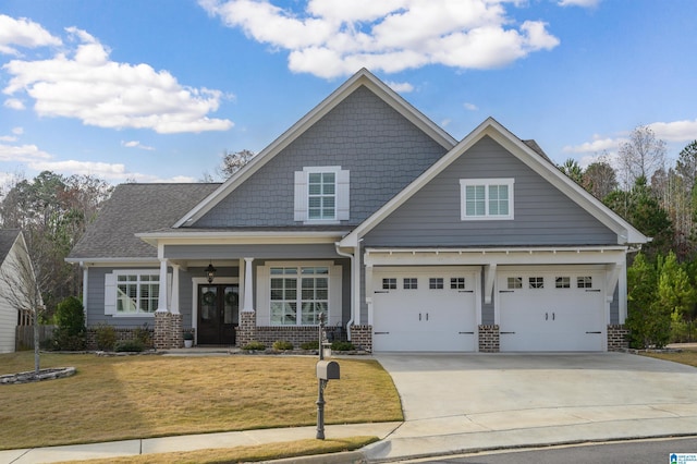 craftsman-style home featuring covered porch, a garage, and a front lawn