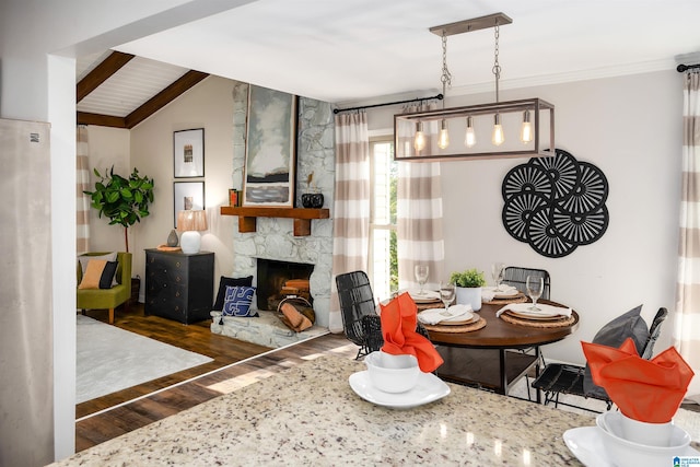 dining area with a fireplace, dark wood-type flooring, and lofted ceiling with beams