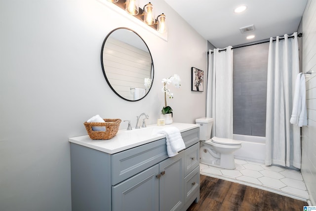 full bathroom with hardwood / wood-style floors, shower / bath combination with curtain, toilet, and vanity