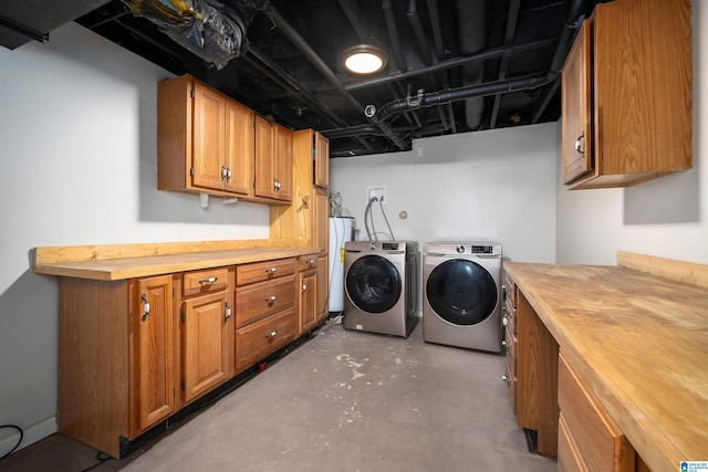 laundry room with cabinets, water heater, and washer and dryer