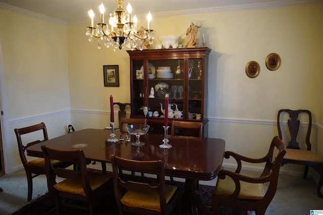 carpeted dining room with a chandelier and ornamental molding