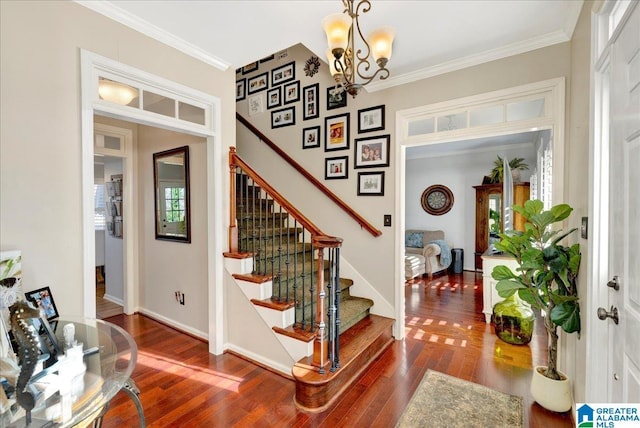 entrance foyer featuring dark wood-type flooring, ornamental molding, and a notable chandelier