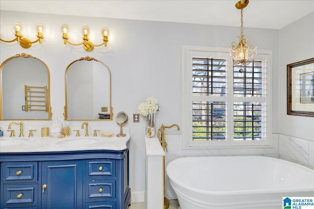 bathroom featuring a wealth of natural light, a washtub, vanity, and a notable chandelier