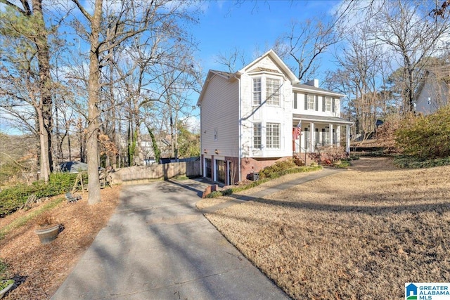 view of front of property with a front lawn, covered porch, and a garage