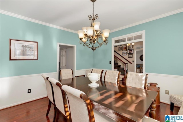 dining area featuring dark hardwood / wood-style floors, ornamental molding, and an inviting chandelier