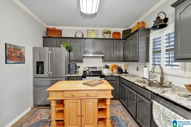 kitchen featuring light stone countertops, appliances with stainless steel finishes, sink, light tile patterned flooring, and crown molding