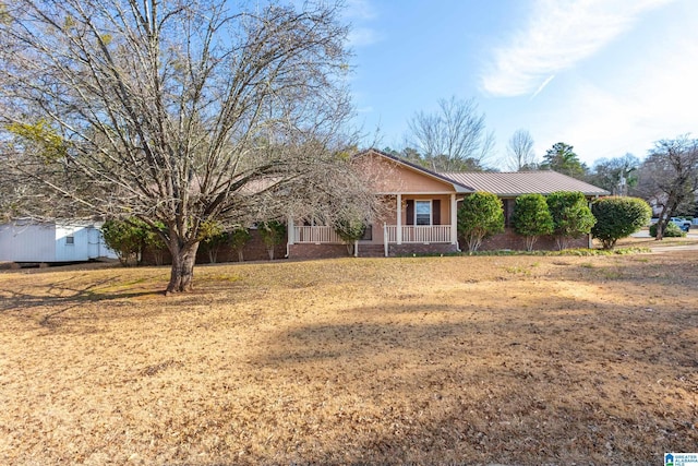 ranch-style house with covered porch and a front yard