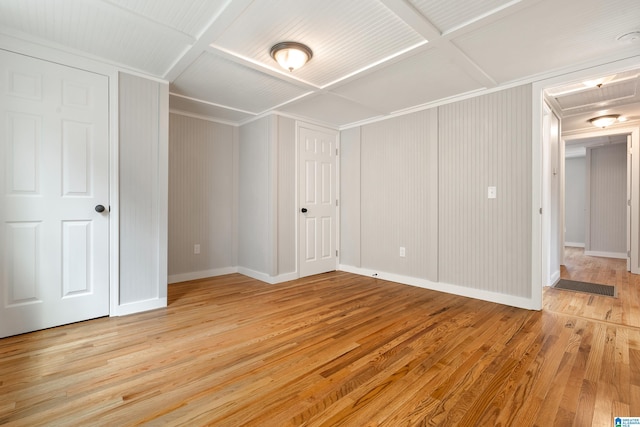 unfurnished bedroom with coffered ceiling and light wood-type flooring