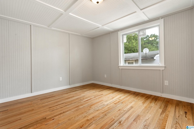 spare room featuring light hardwood / wood-style floors and coffered ceiling