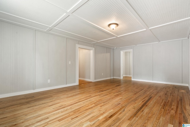 empty room with hardwood / wood-style floors and coffered ceiling