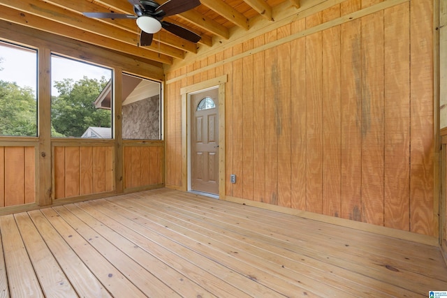 unfurnished sunroom featuring beam ceiling, ceiling fan, and wood ceiling