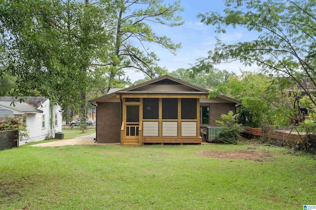 rear view of house featuring a yard and central AC unit