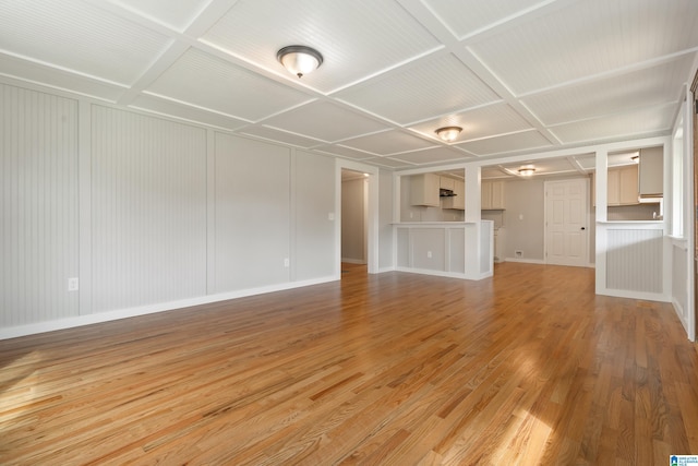 unfurnished living room with light hardwood / wood-style floors and coffered ceiling