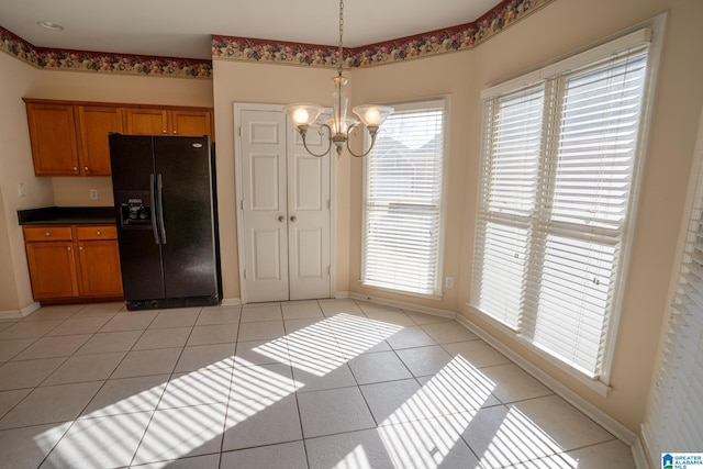 kitchen with pendant lighting, an inviting chandelier, black fridge, and light tile patterned flooring