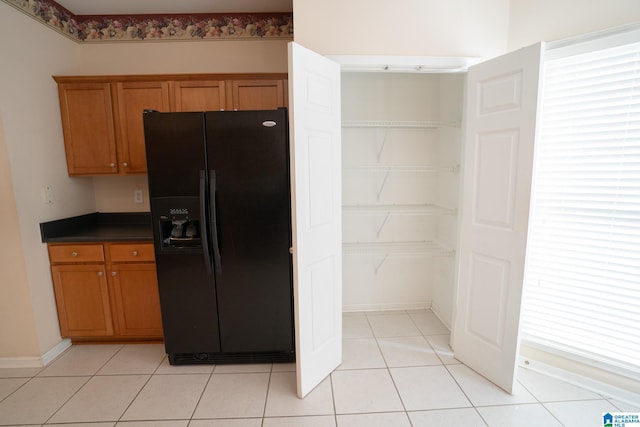 kitchen with black fridge and light tile patterned floors