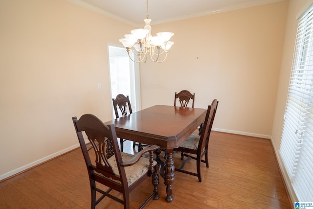 dining room featuring a chandelier, light hardwood / wood-style flooring, and ornamental molding