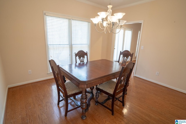 dining room featuring hardwood / wood-style floors, ornamental molding, and an inviting chandelier